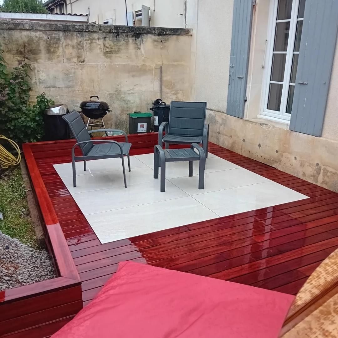 Terrasse avec mobilier de jardin et barbecue.