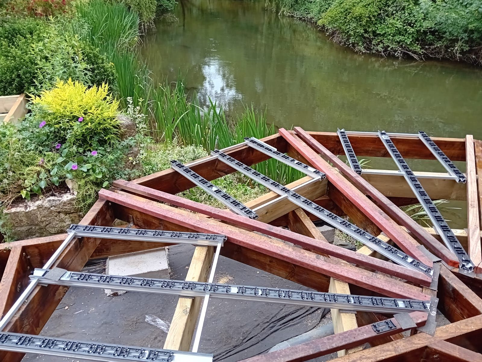 La structure d'une terrasse est en construction près d'un plan d'eau.