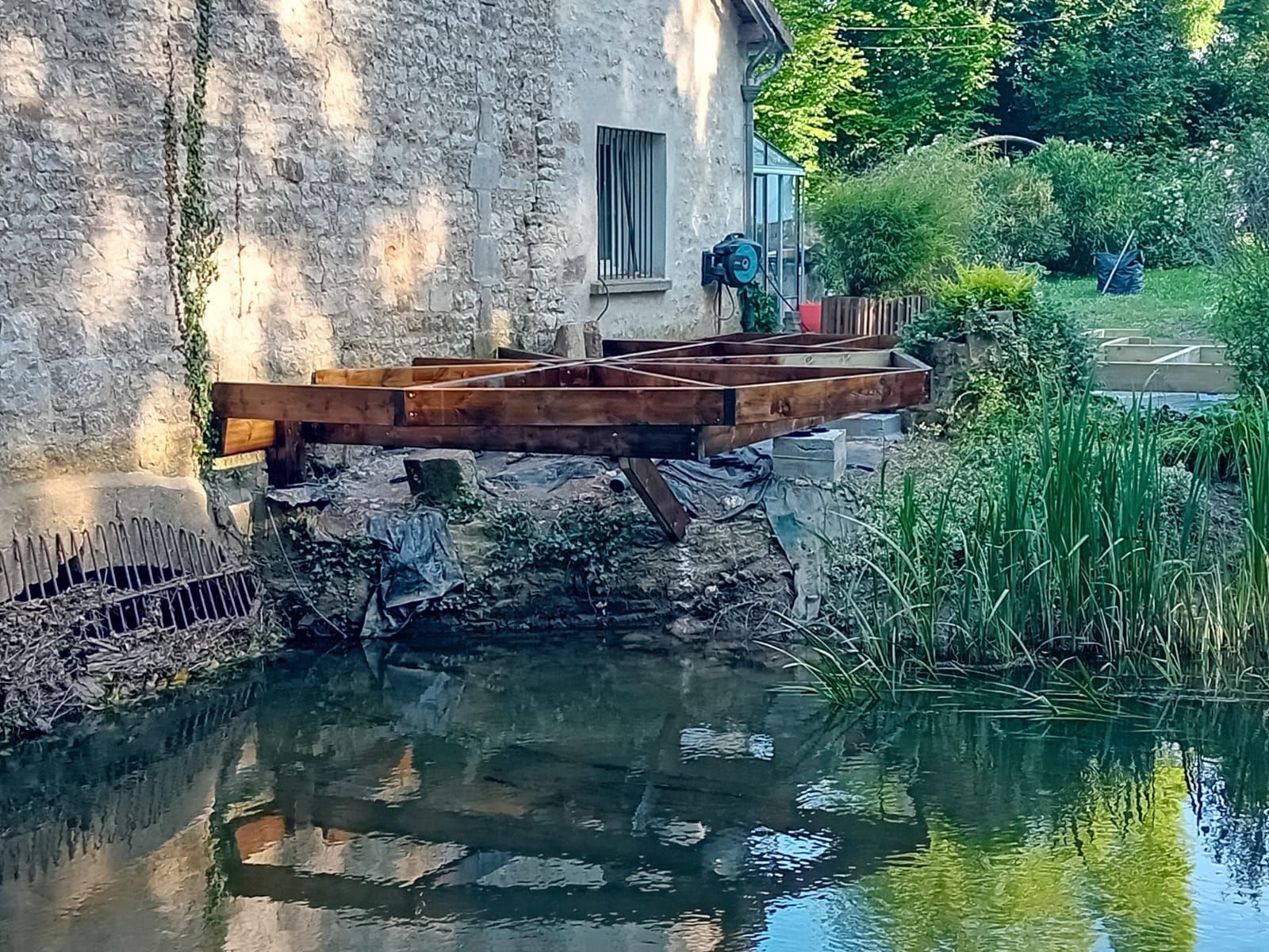 Réparation des fondations d'un bâtiment en pierre au bord d'un plan d'eau.