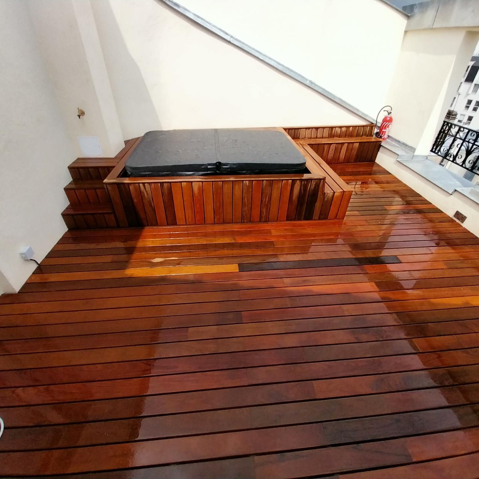 Terrasse en bois avec jacuzzi et escalier.