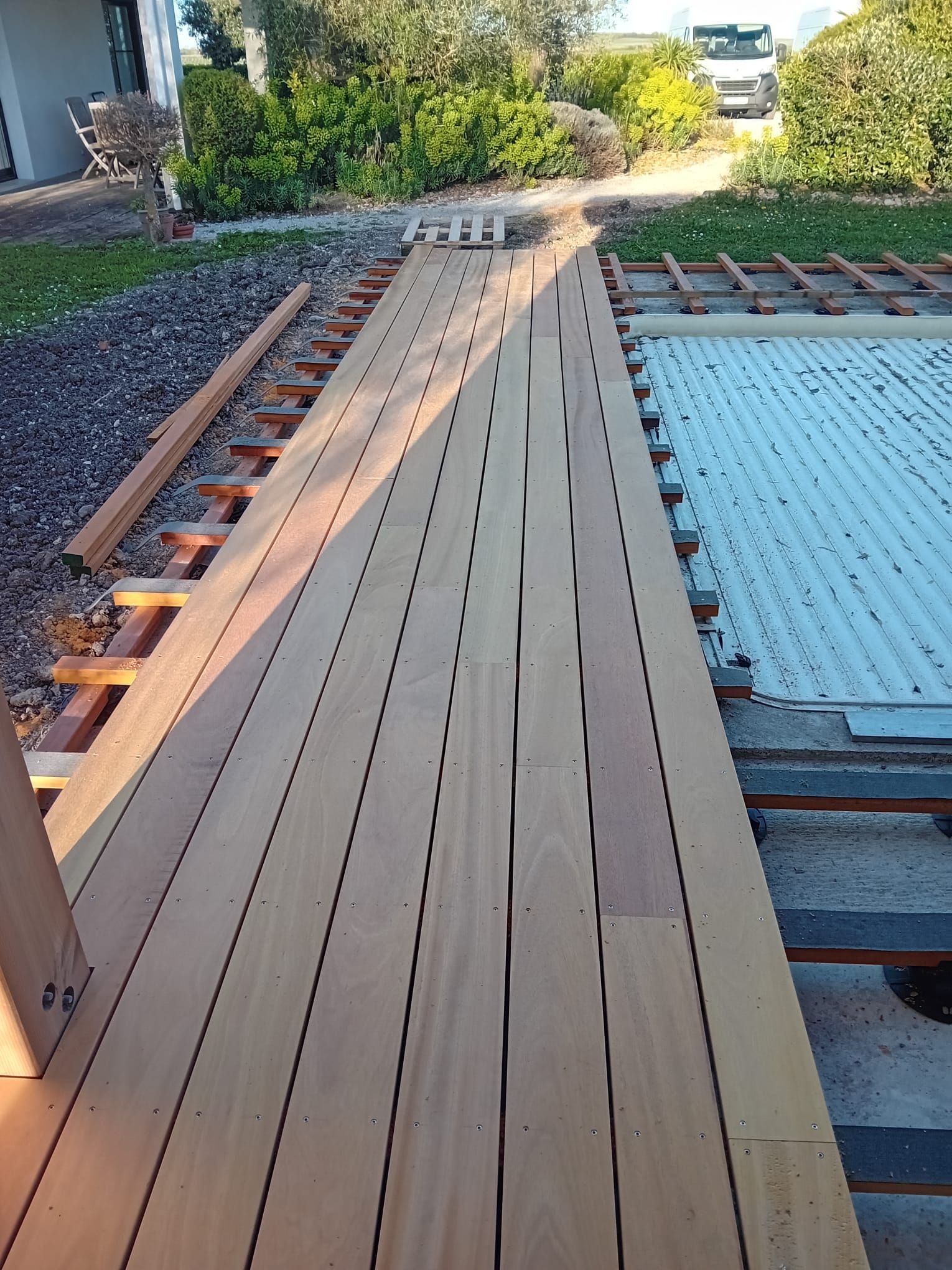 Terrasse en bois en construction, avec pose de nouvelles planches.