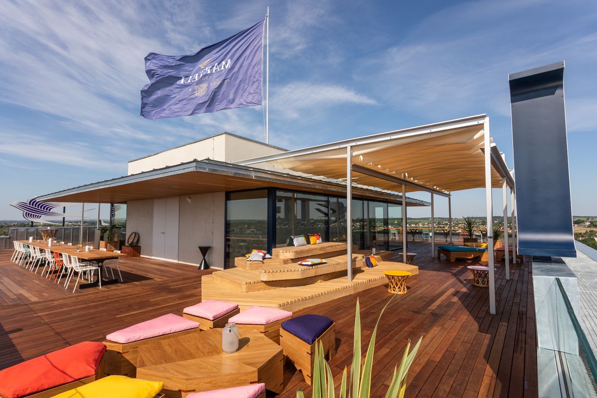 Terrasse sur le toit avec tables, sièges et drapeau.