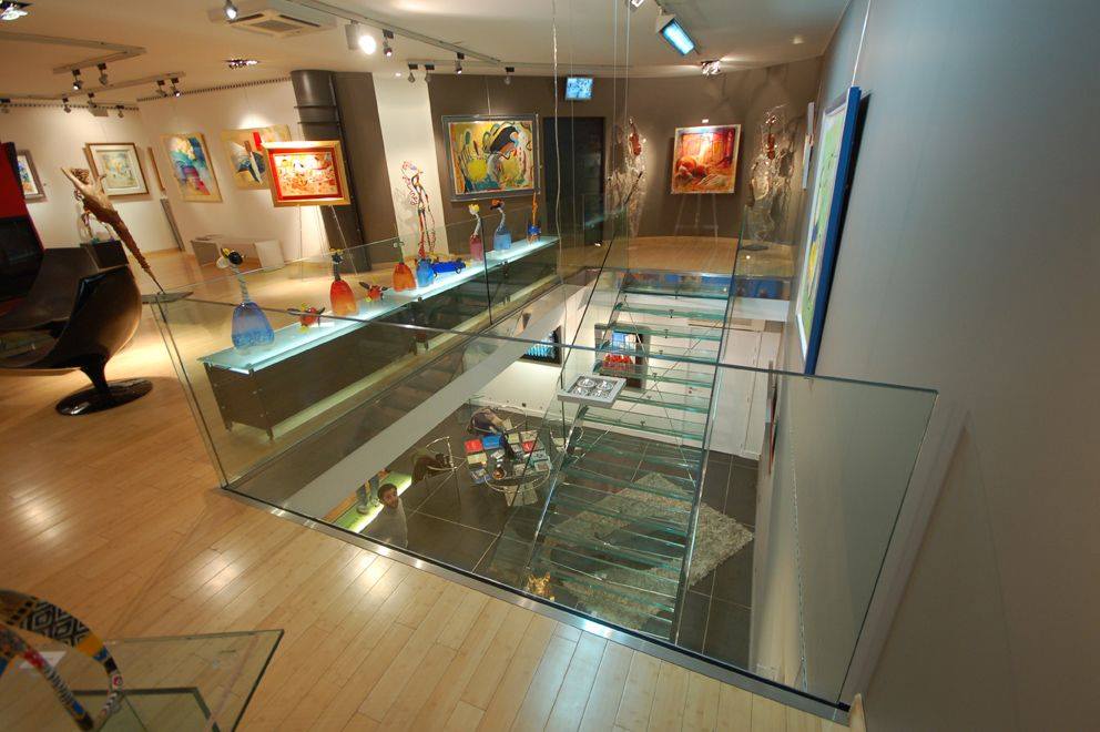 Salle d'exposition avec garde-corps et escalier en verre