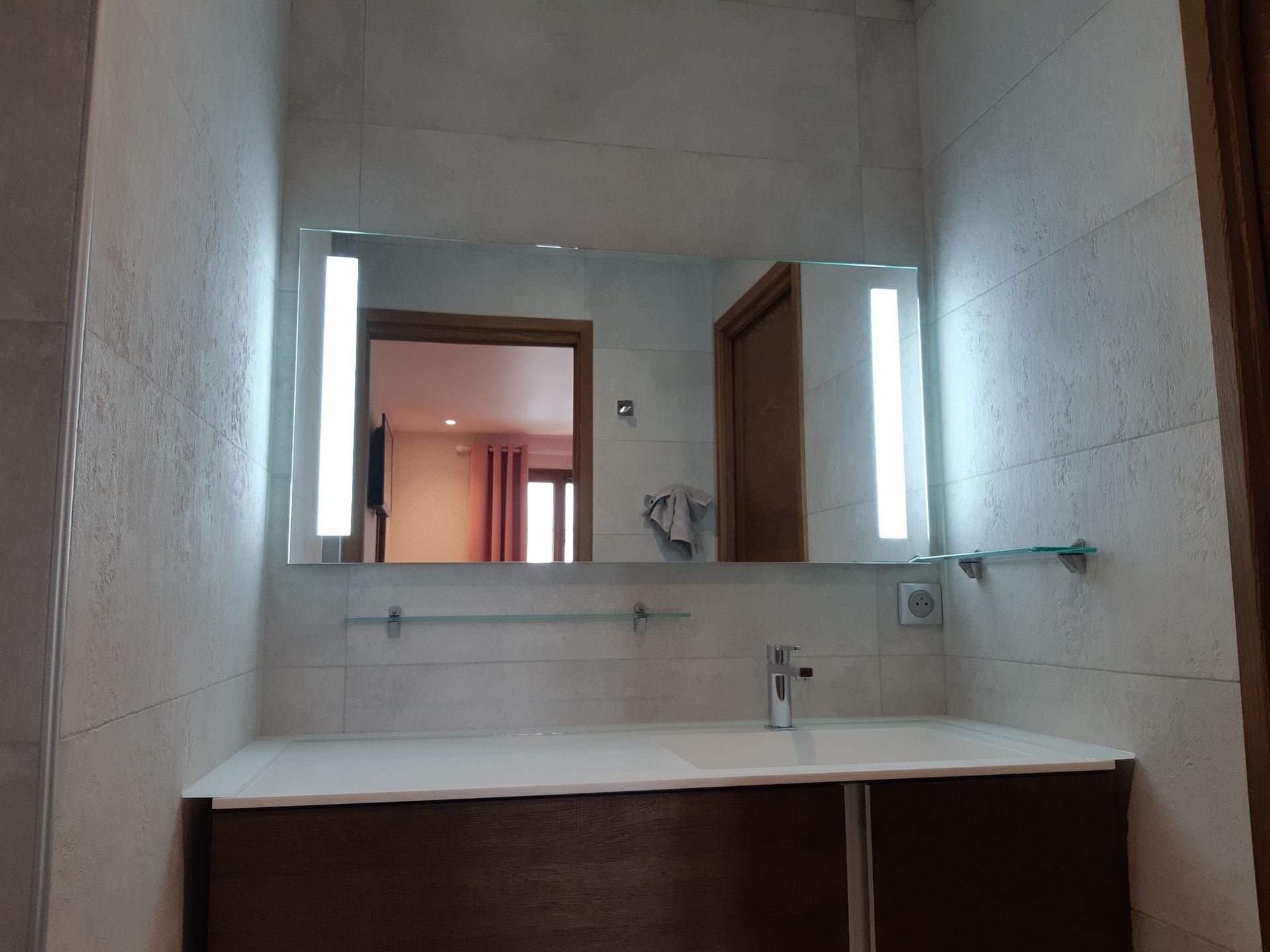 Salle de bains avec miroir à fond lumineux