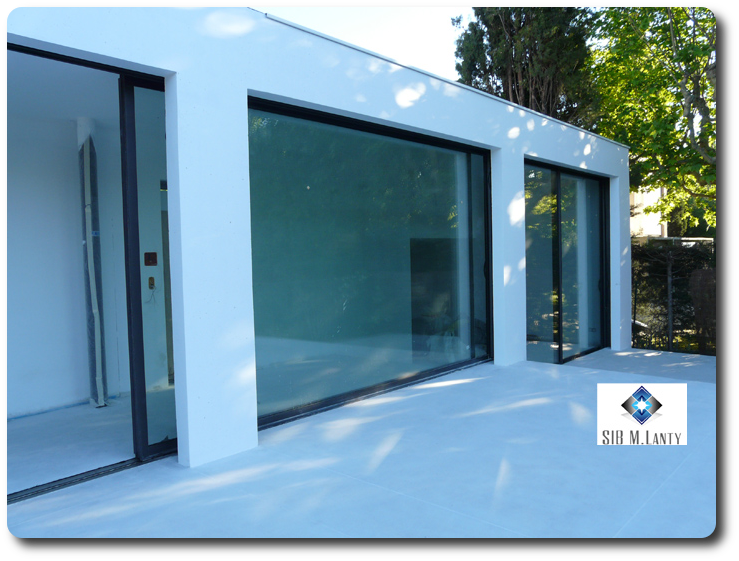 Façade vitrée avec porte coulissante d'une maison réalisé par Sib M Lanty