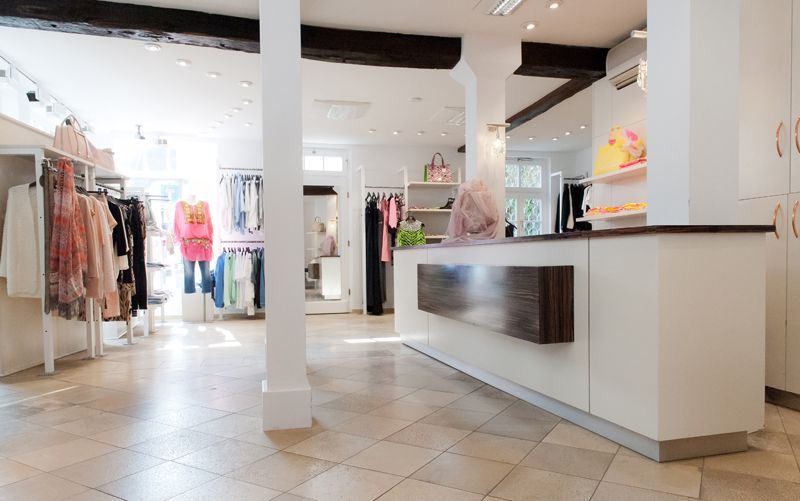 Eine Frau steht an einer Theke in einem Bekleidungsgeschäft.