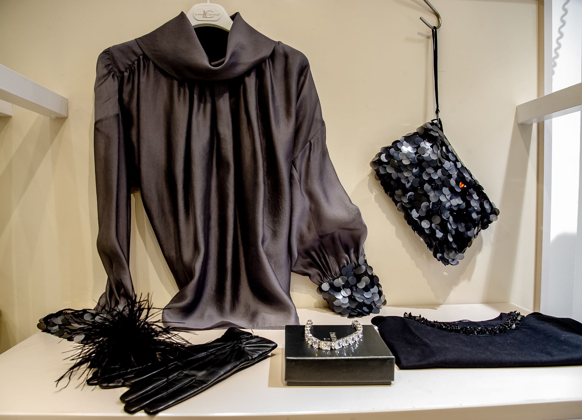 Ein Raum mit auf einer Stange hängender Kleidung und einer Pflanze.