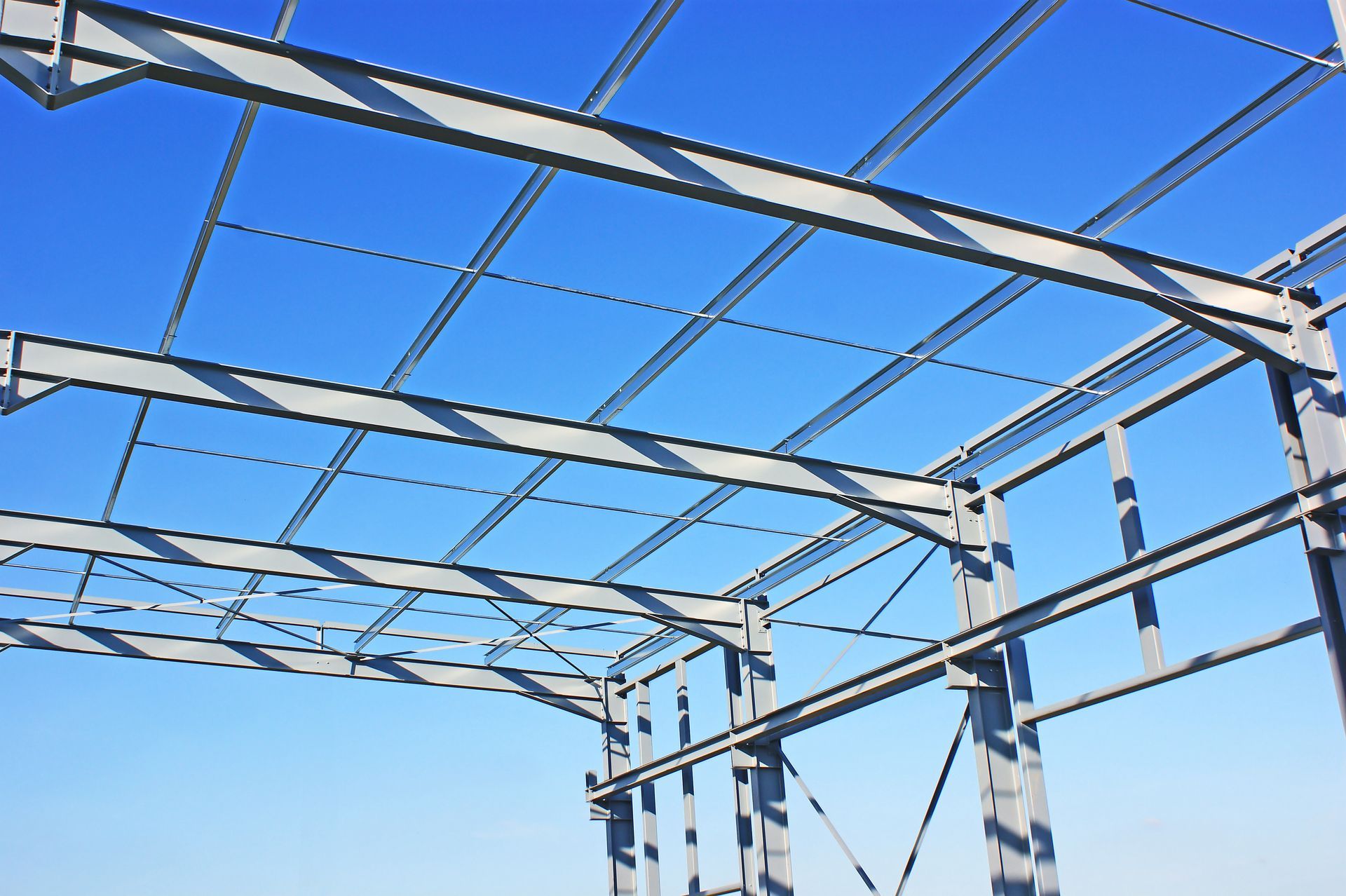 Ossature métallique d’un bâtiment en construction sur fond de ciel bleu dégagé