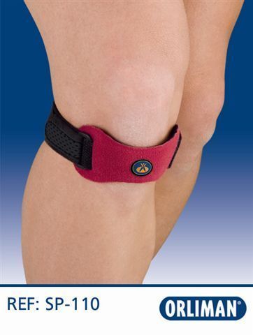 Correa de soporte para la rodilla con acolchado rosa que se envuelve alrededor de una pierna doblada.