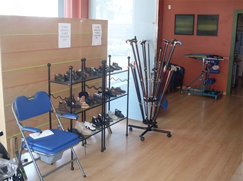 Gimnasio/trastero interior con aparatos de ejercicio, una silla azul y suelo de madera junto a una ventana.