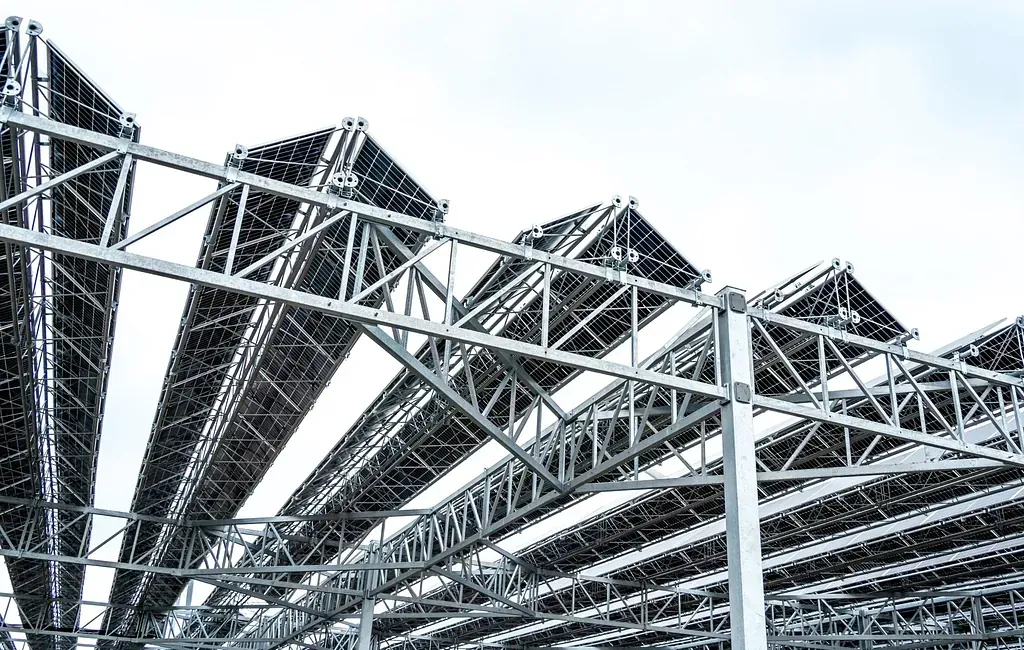 Un primer plano de una estructura metálica con techo en construcción.