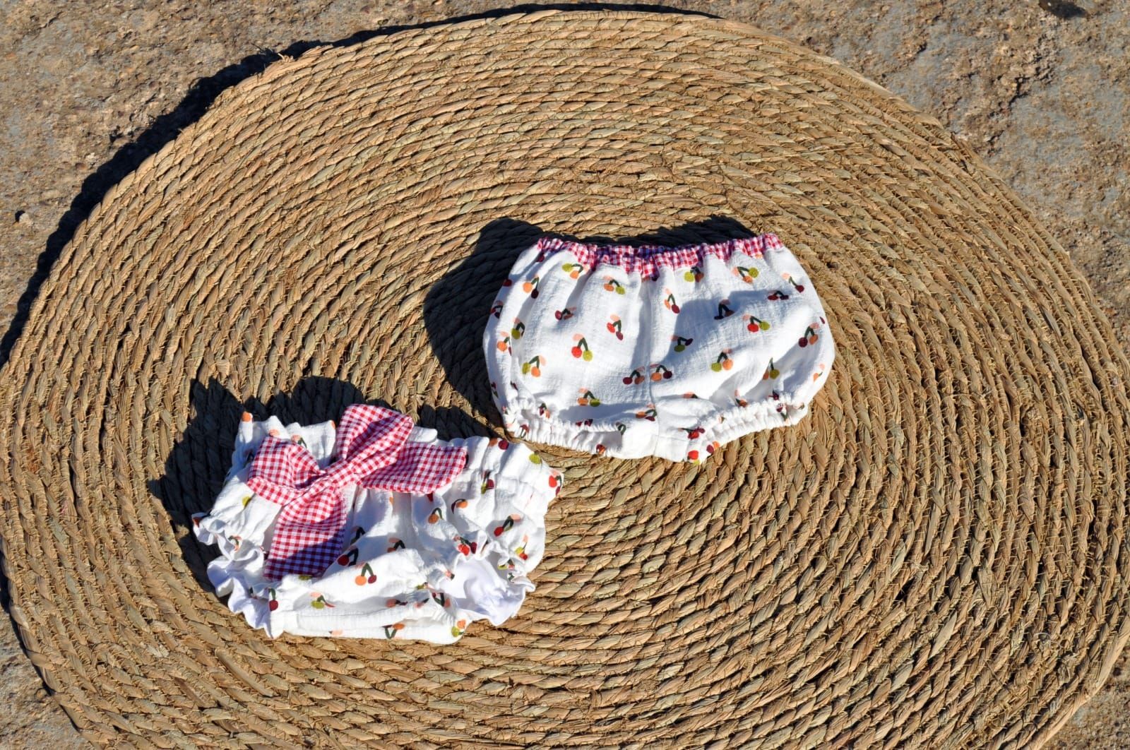 Dos pañales están sentados sobre una estera de mimbre en el suelo.