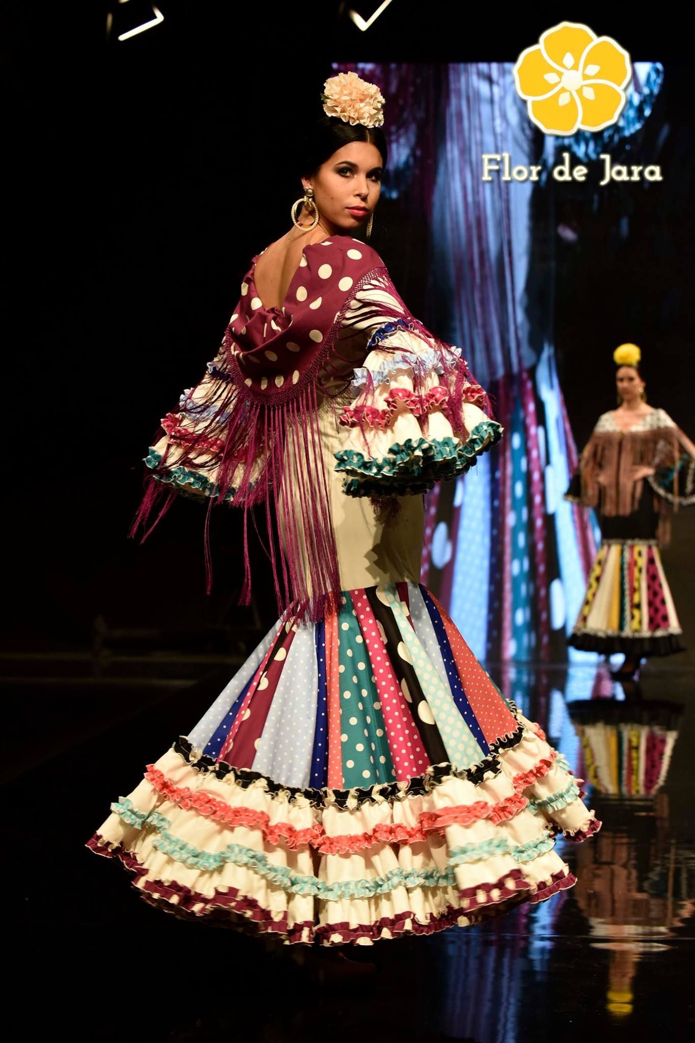 Una mujer con un vestido colorido camina por la pasarela.