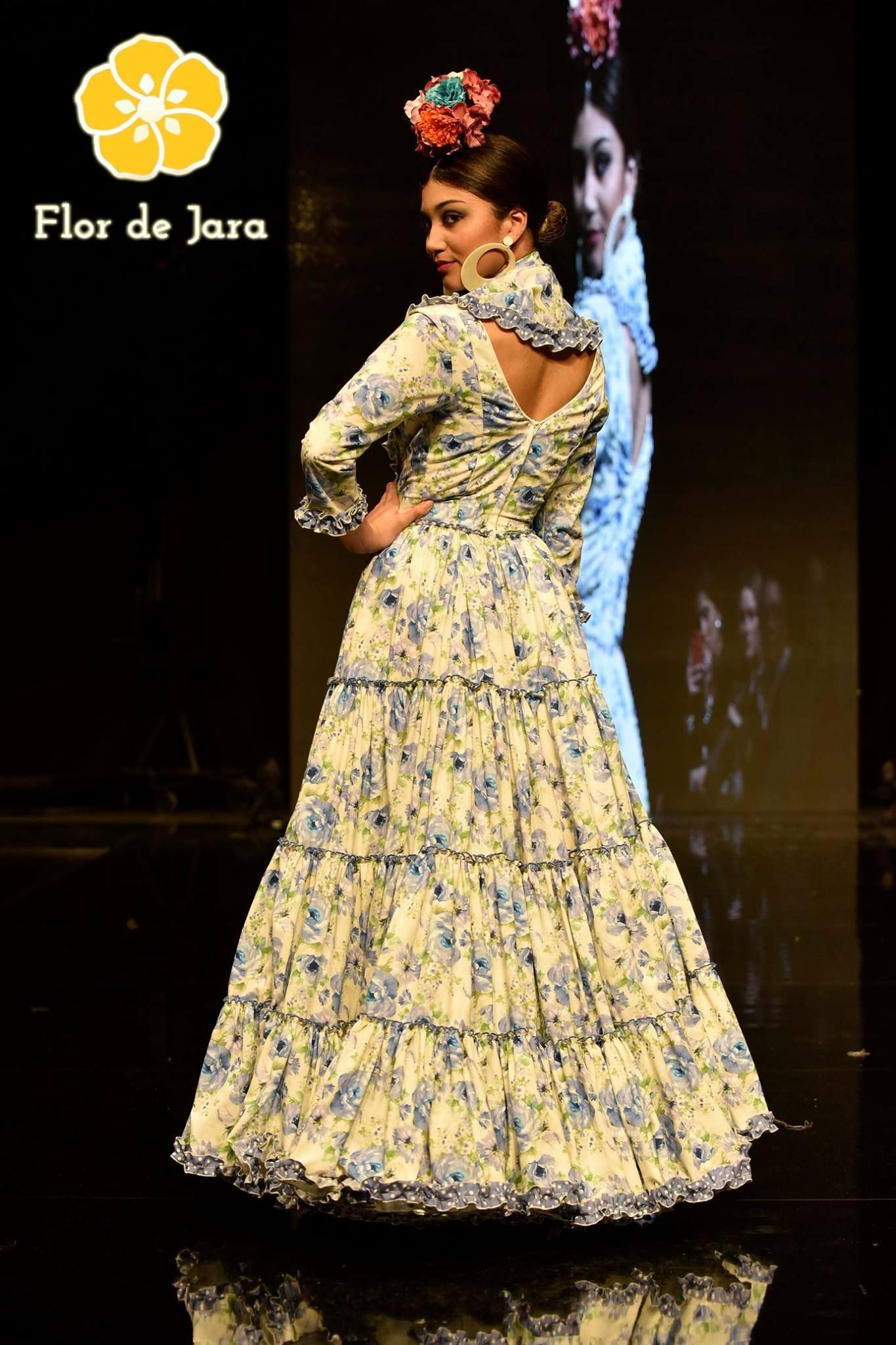 Una mujer camina por una pasarela con un vestido floreado.