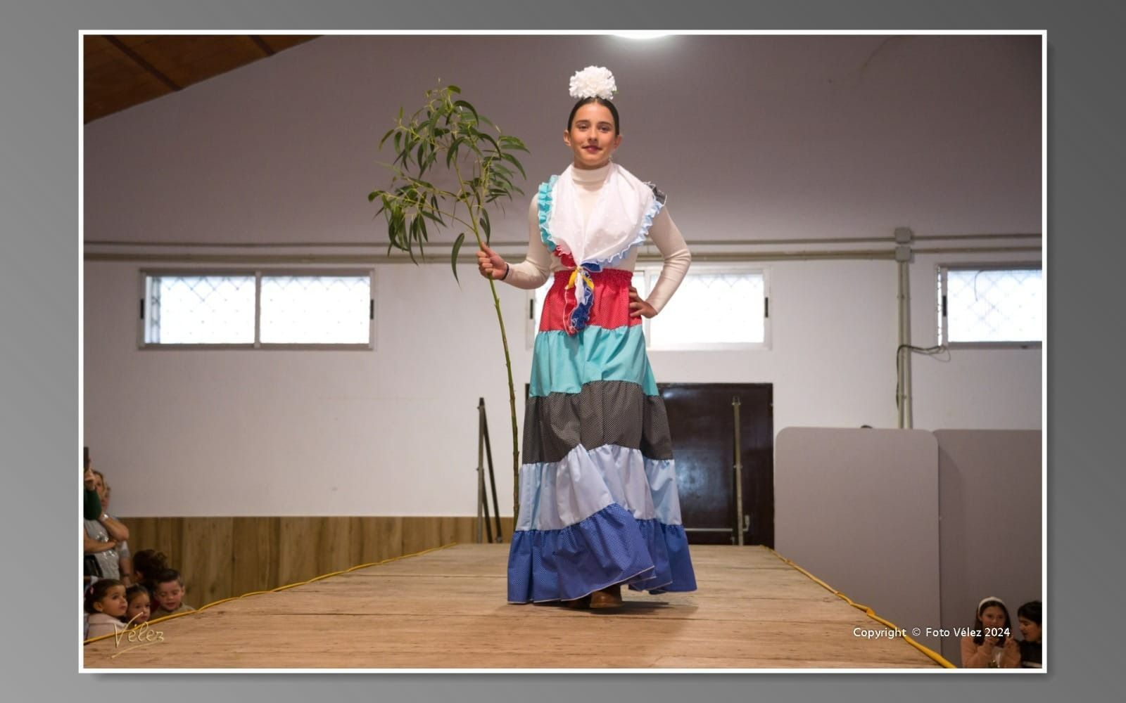 Una mujer con un vestido colorido camina por una pasarela.