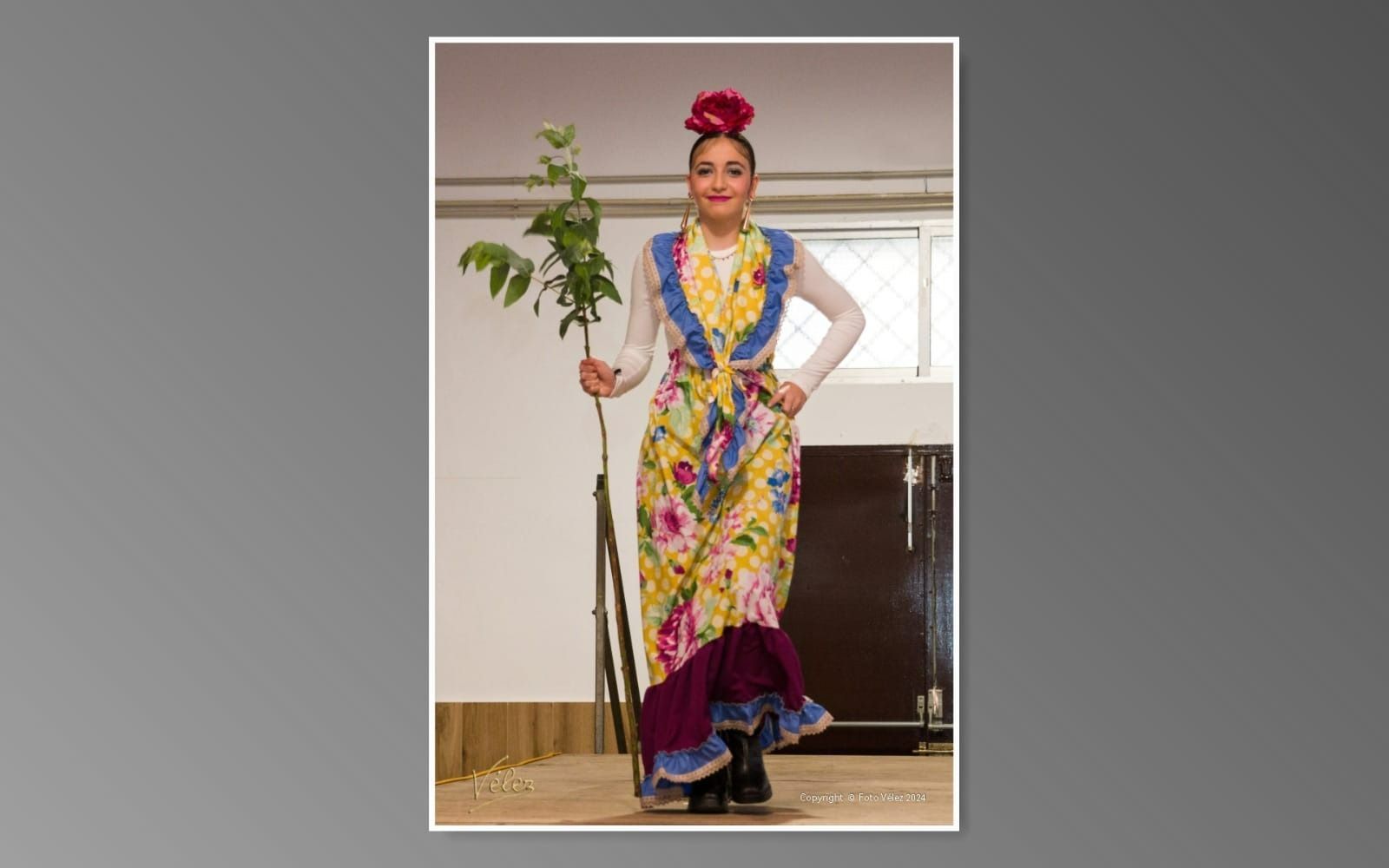 Una mujer con un vestido colorido sostiene una planta.