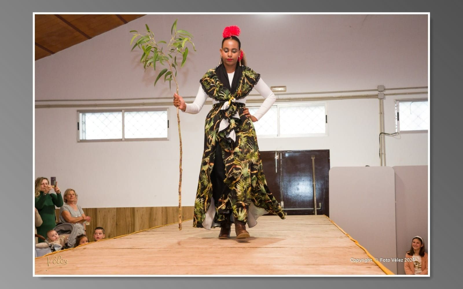 Una mujer con un vestido de camuflaje camina por una pasarela.