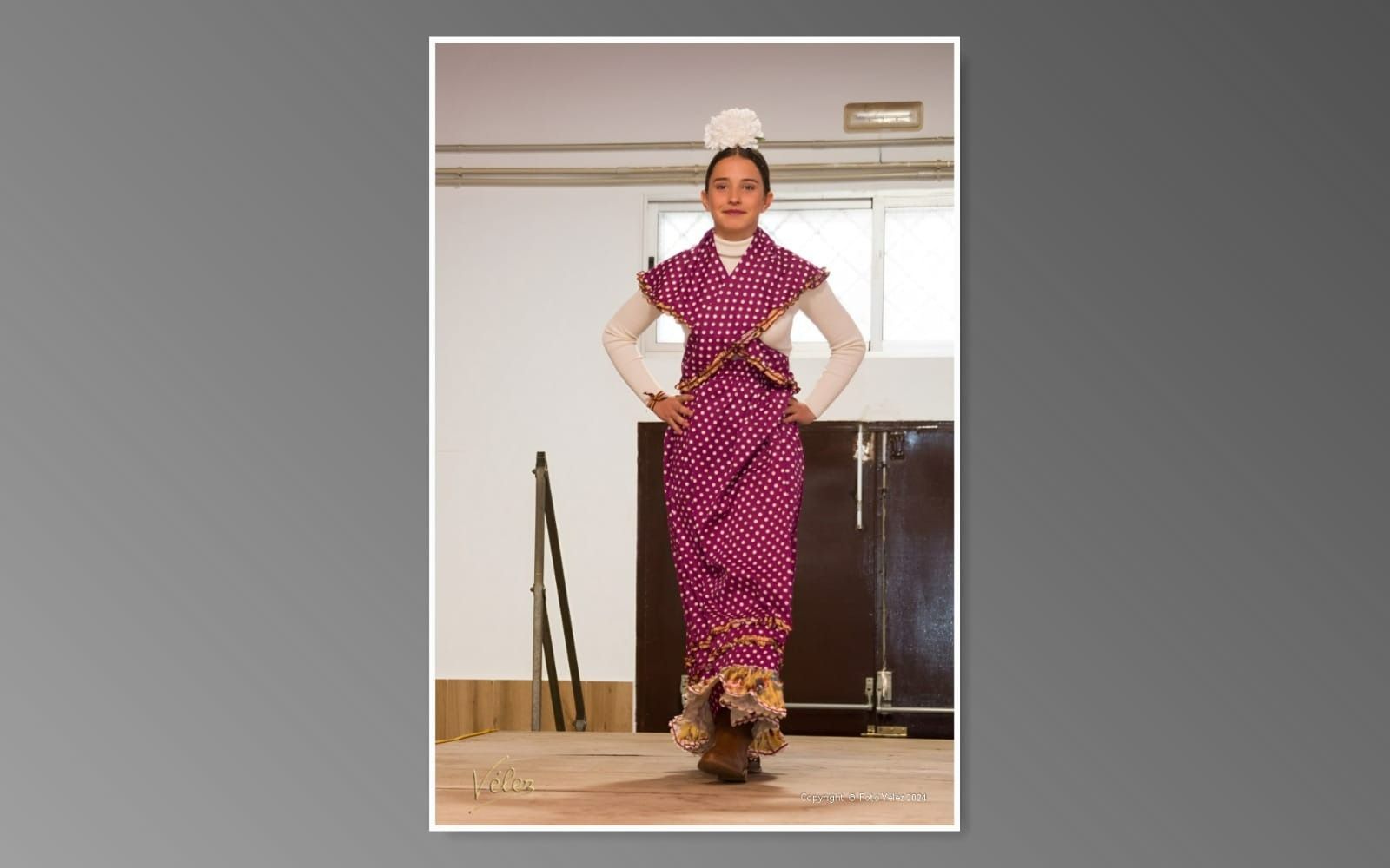 Una mujer con un vestido morado está de pie en un escenario.