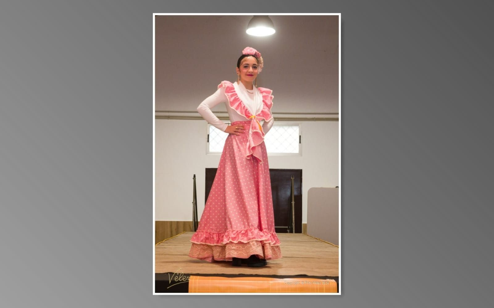 Una mujer con un vestido rosa está parada en un escenario.