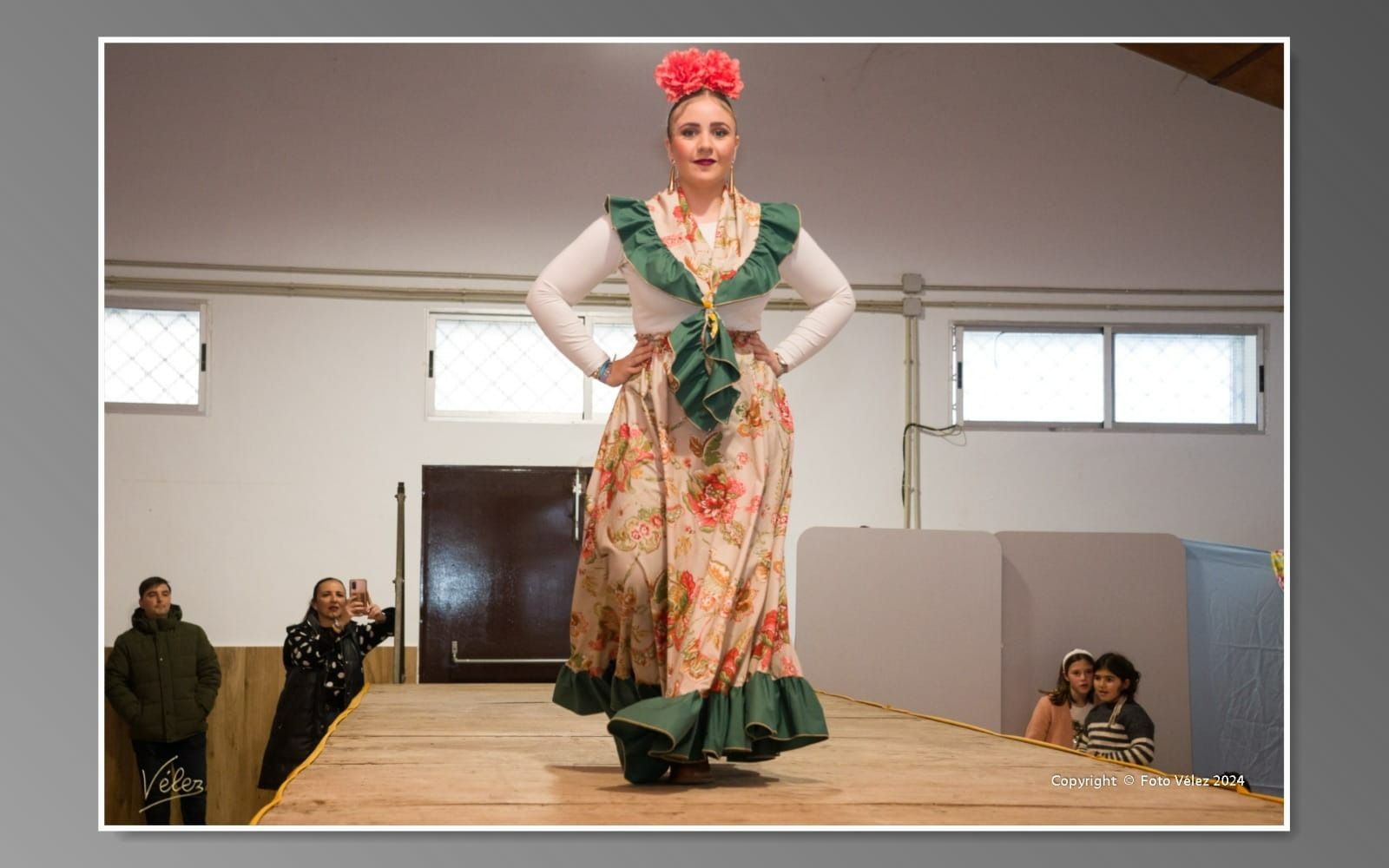 Una mujer con un vestido floral camina por una pasarela.