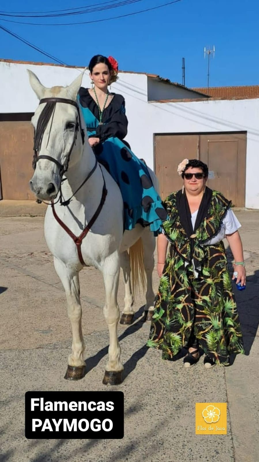 Una mujer monta un caballo blanco al lado de una mujer con un vestido verde.