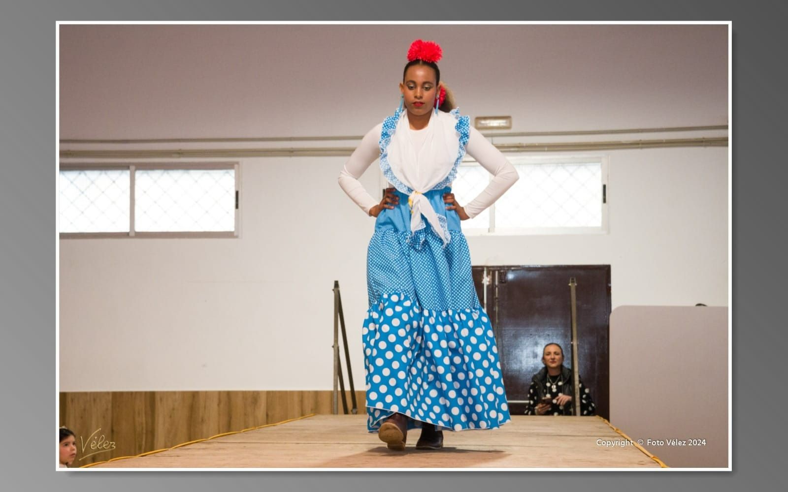 Una mujer con un vestido de lunares azules y blancos está bailando