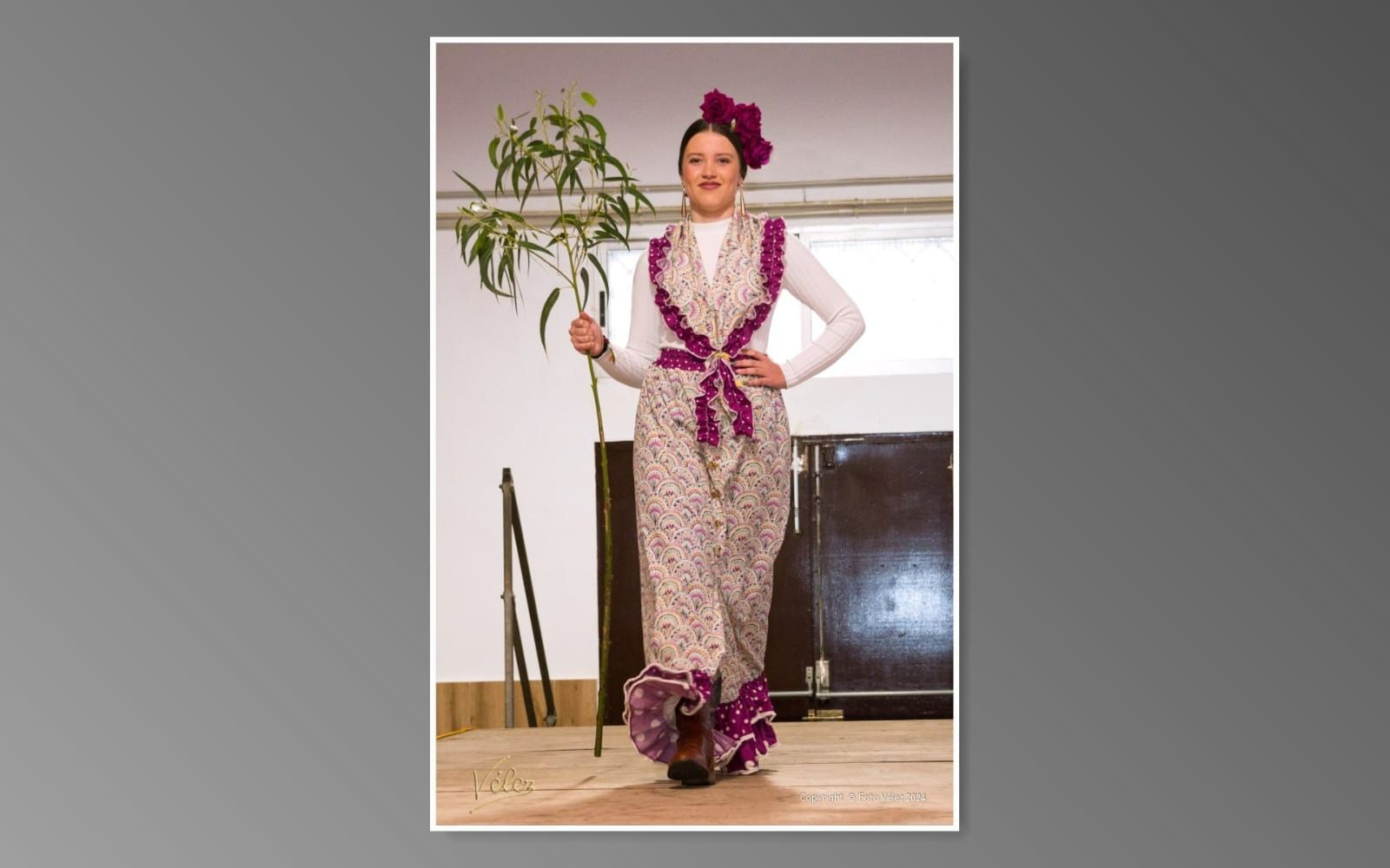 Una mujer con un vestido morado sostiene una planta.