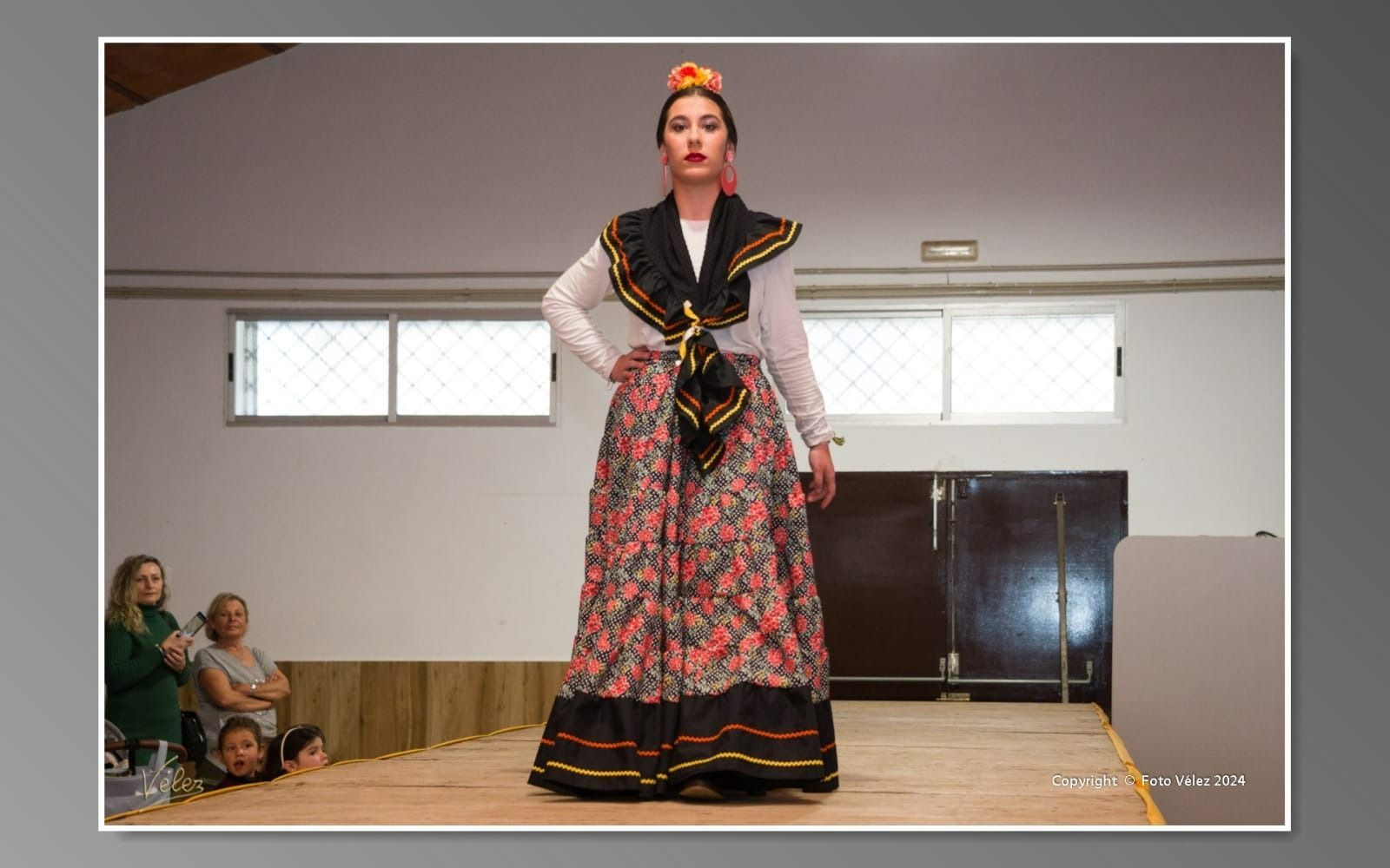 Una mujer con un vestido floral camina por una pasarela.