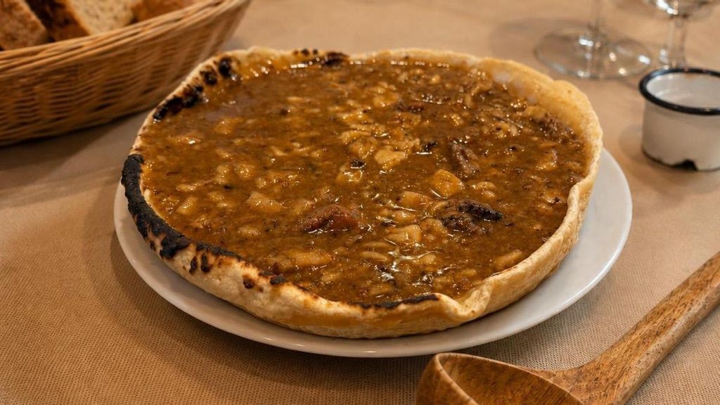 Pizza de queso en un plato blanco sobre una mesa de madera, con una cesta y un pequeño recipiente para la salsa cerca.