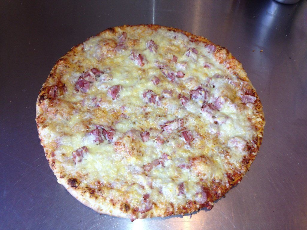 Pizza base crème fraîche avec fromage et lardons