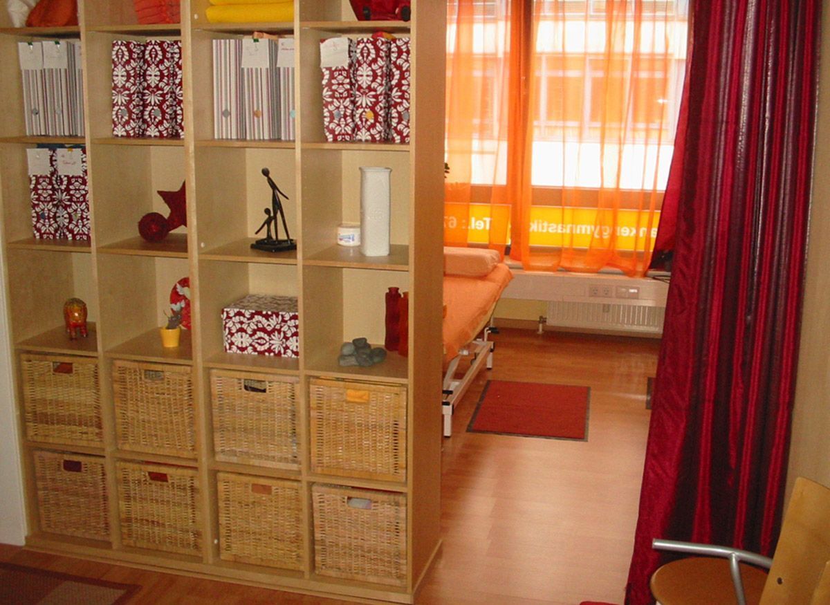 Behandlungsraum mit einem großen Regal als Raumtrenner