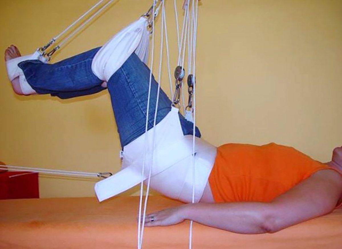 Eine Frau liegt auf einem Schlingentisch in der Praxis