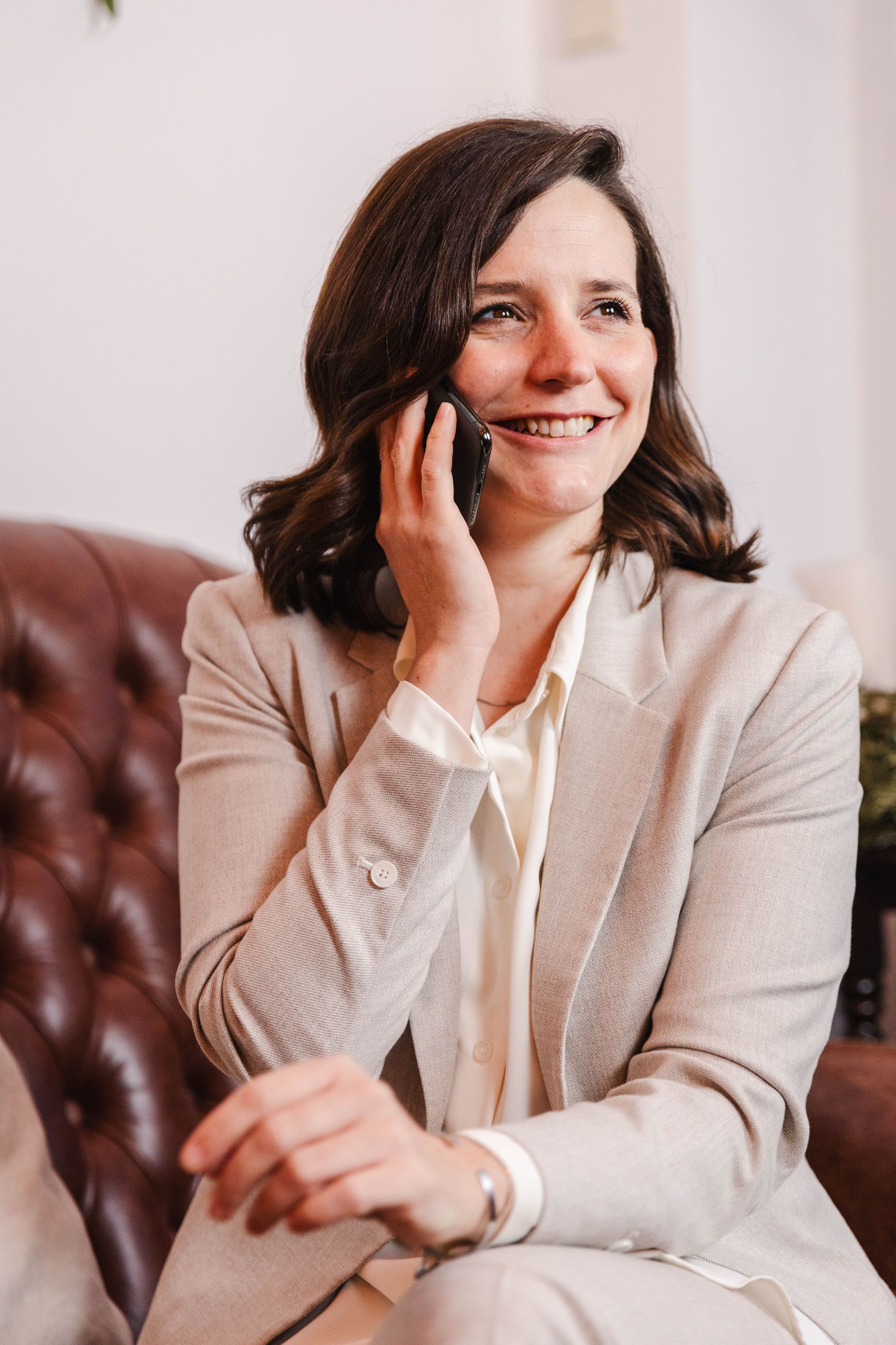 Frau lächelt, während sie ein Selfie mit einem Smartphone macht.