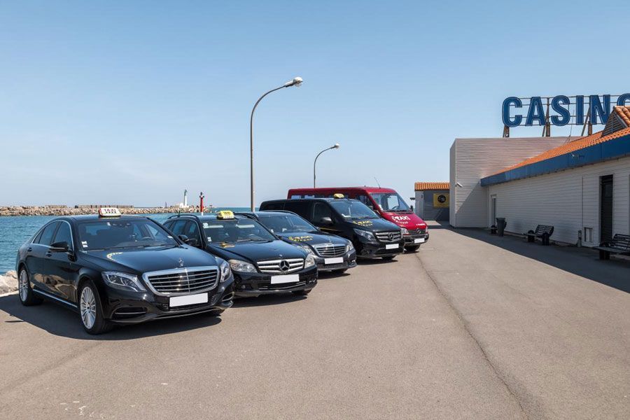 Des taxis stationnés près d'un casino en bord de mer par une journée ensoleillée.