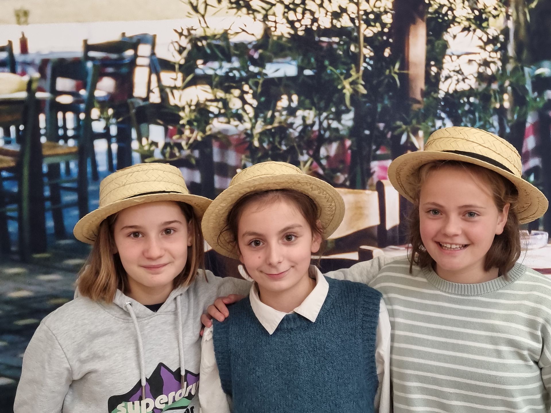 Des filles qui sourient devant des chaises en bois