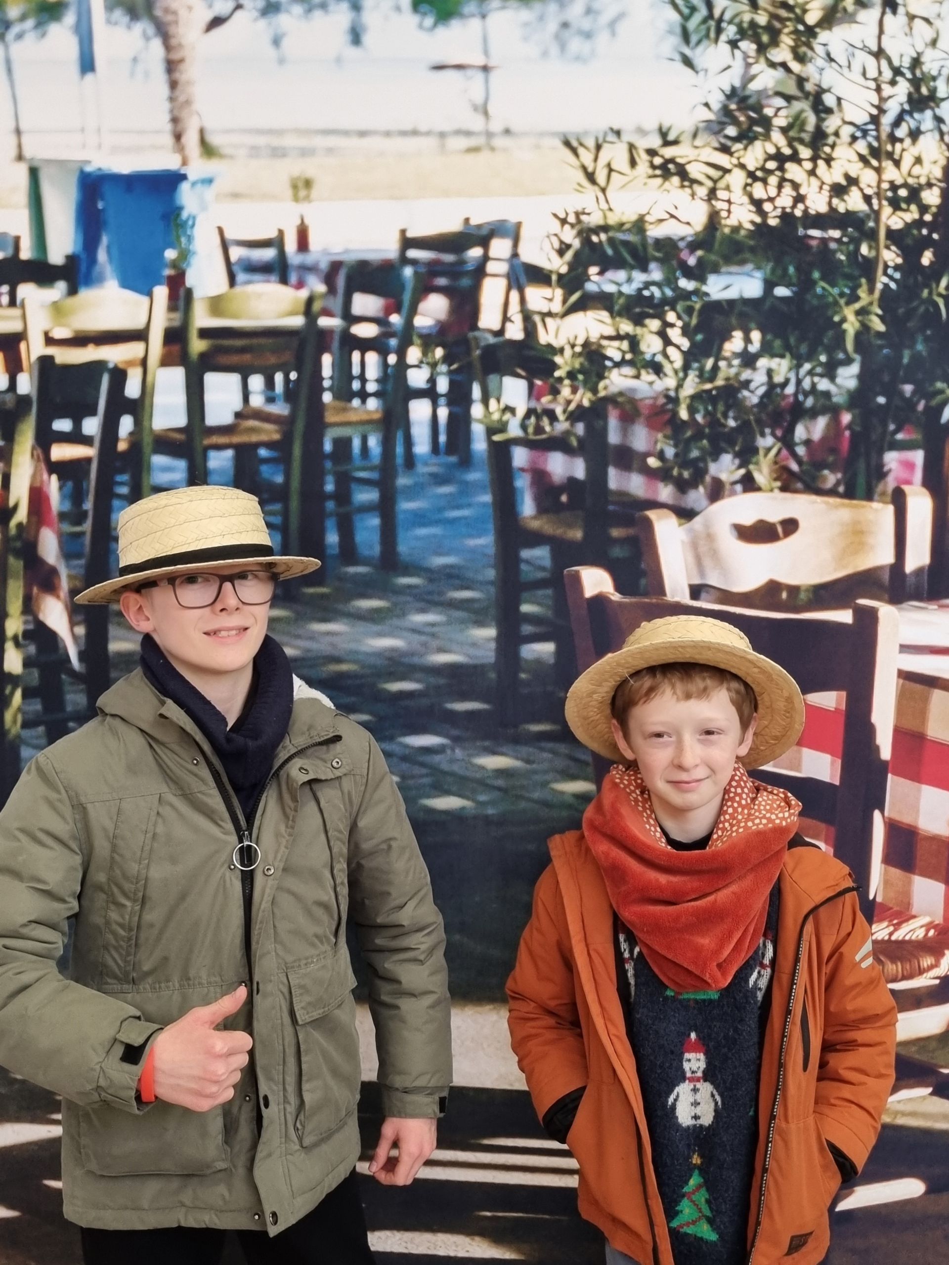 Deux collégiens qui font une photo devant une affiche avec des tables