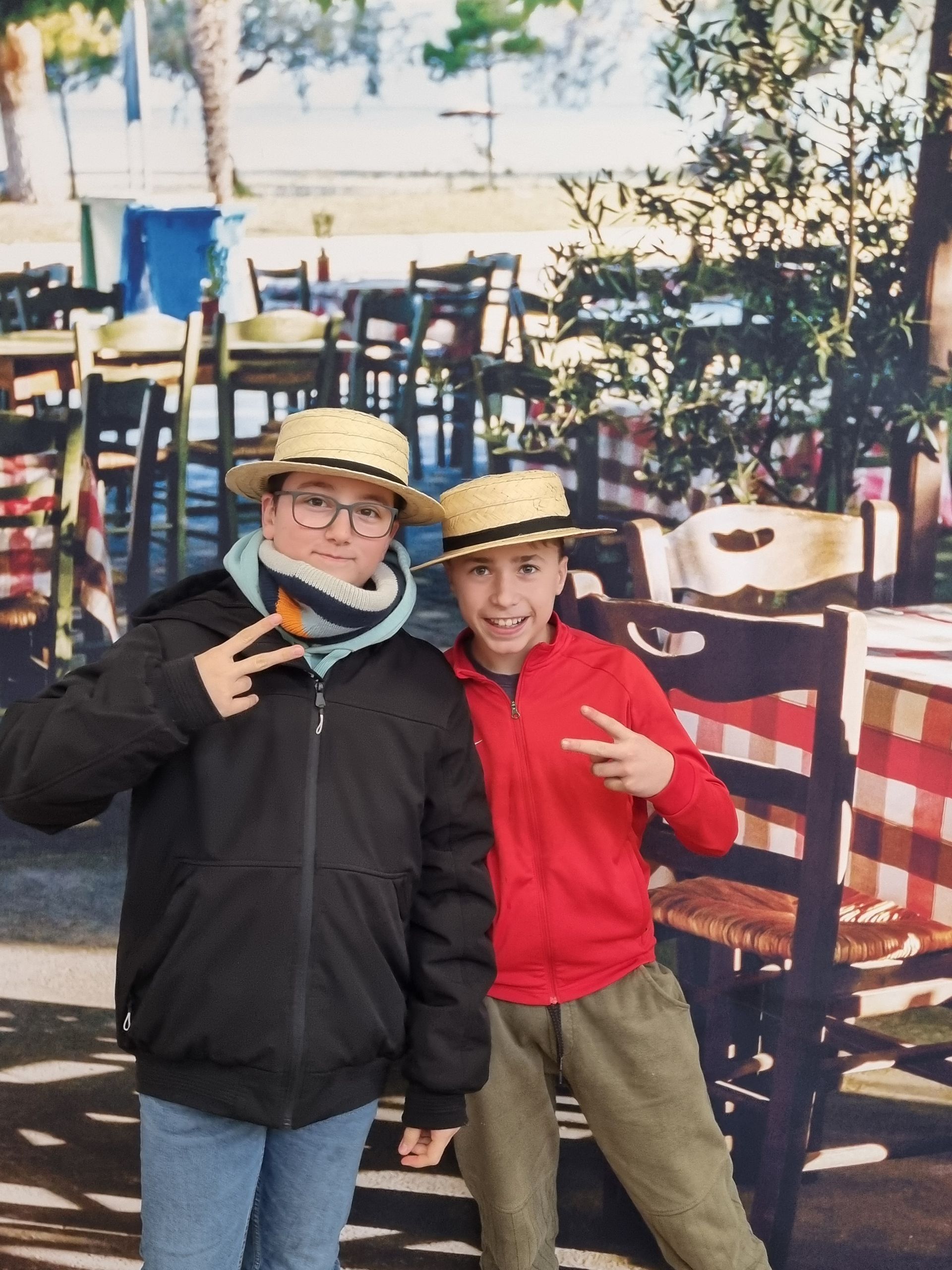 Deux garçons qui prennent la pose devant des tables avec des nappes à carreaux