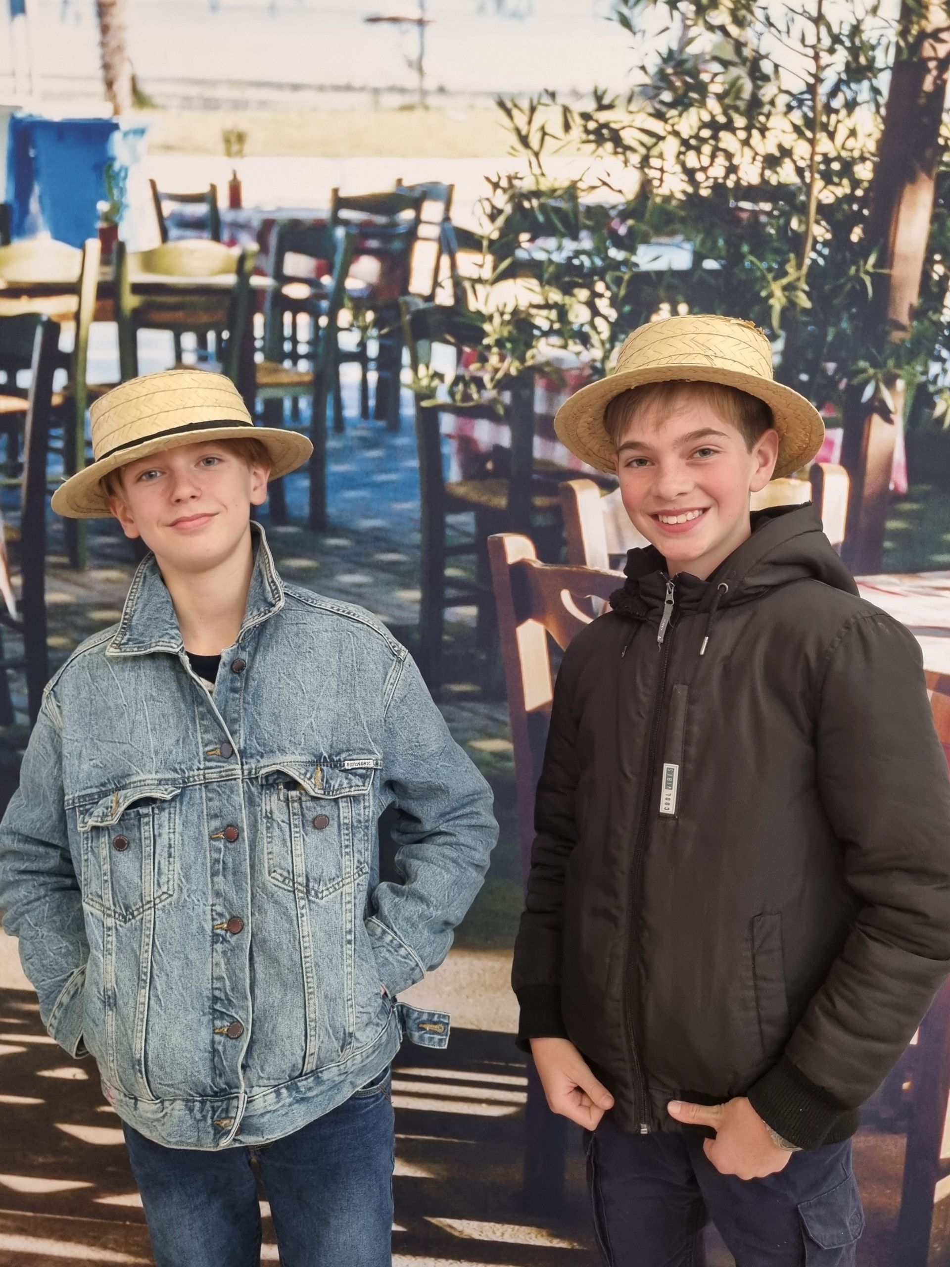Deux élèves qui portent un chapeau de pailles et qui sourient pour une photo