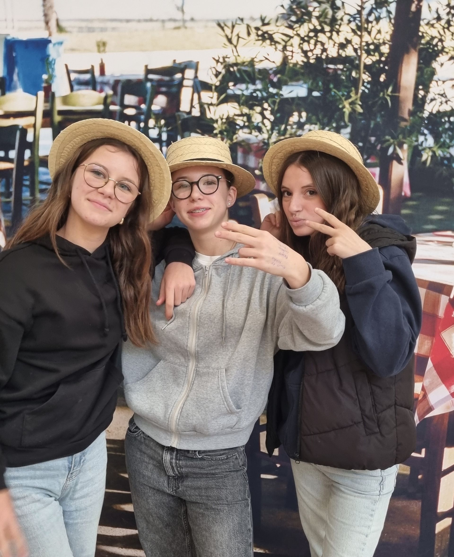 Trois collégiens avec des chapeaux en pailles qui prennent la pose