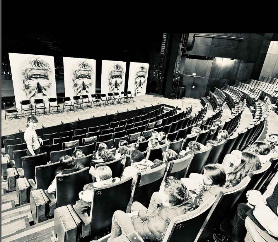 Des personnes assises dans un amphithéâtre