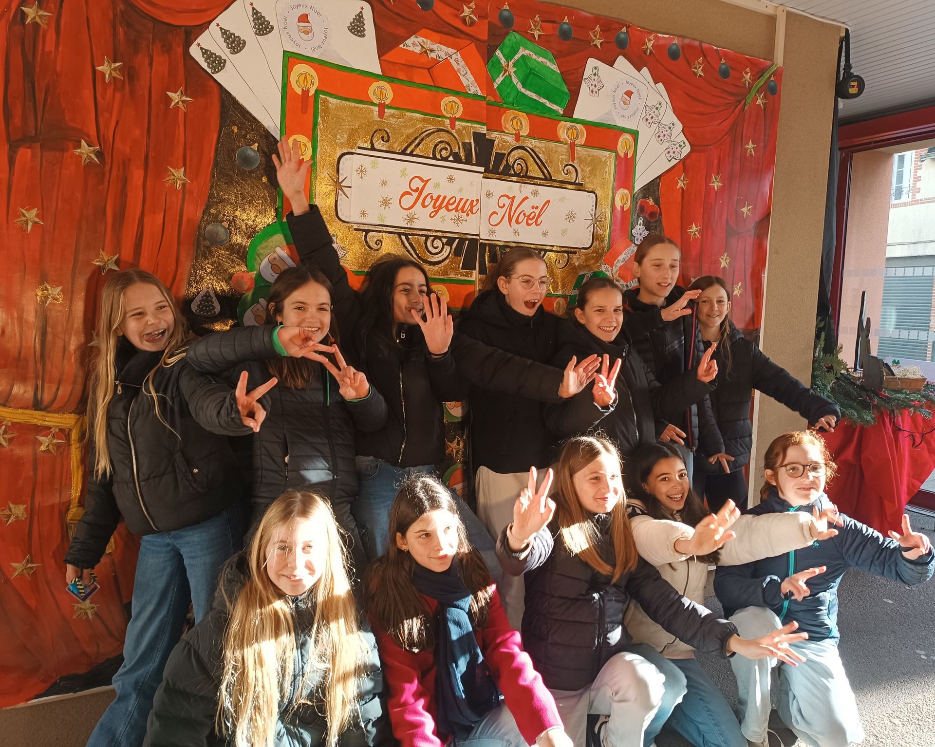 Un groupe d'élève devant une pancarte de Noël