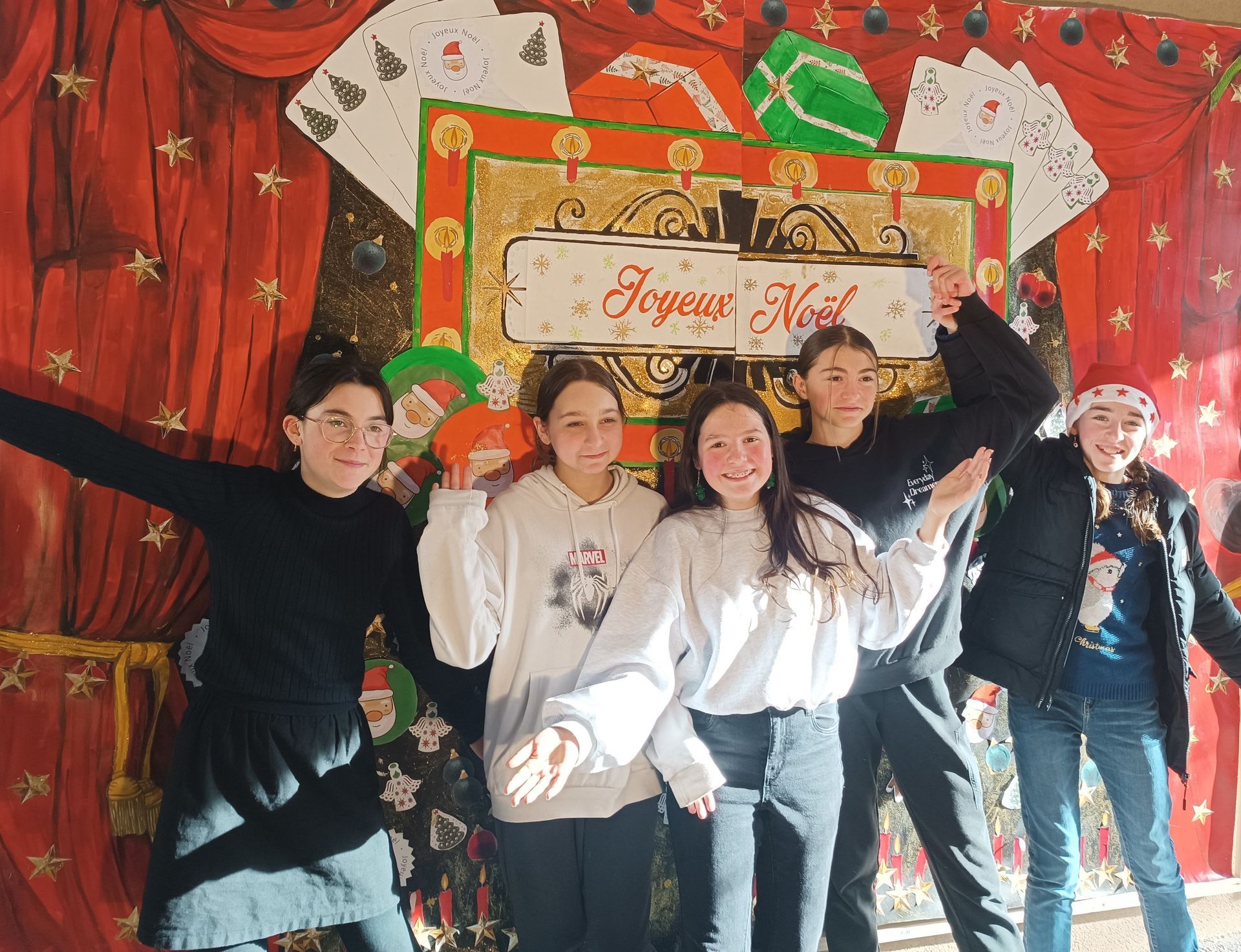 Des collégiens qui prennent la pose devant un décor de Noël avec écrit