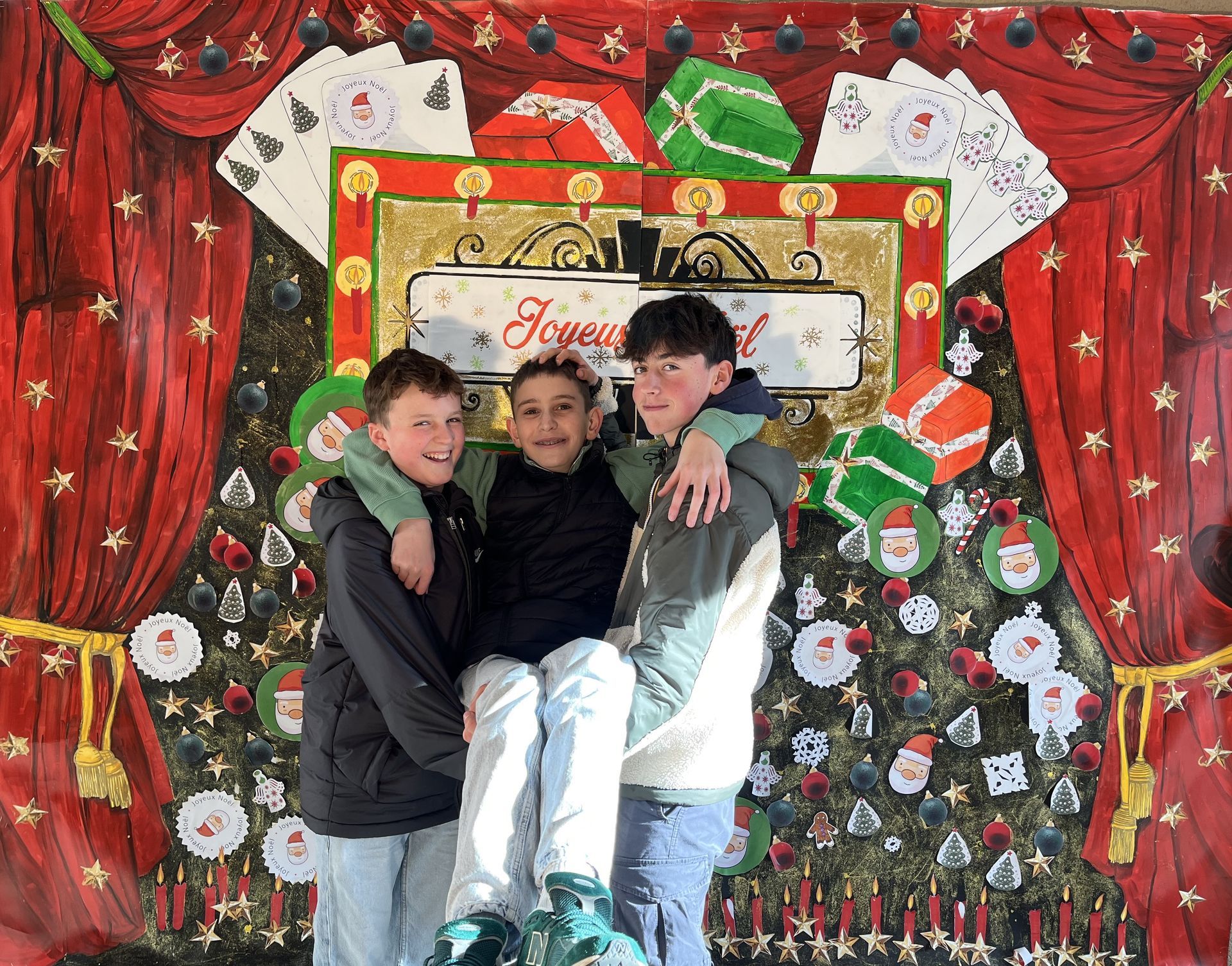 Trois collégiens qui prennent la pose devanr un décor pour les fêtes