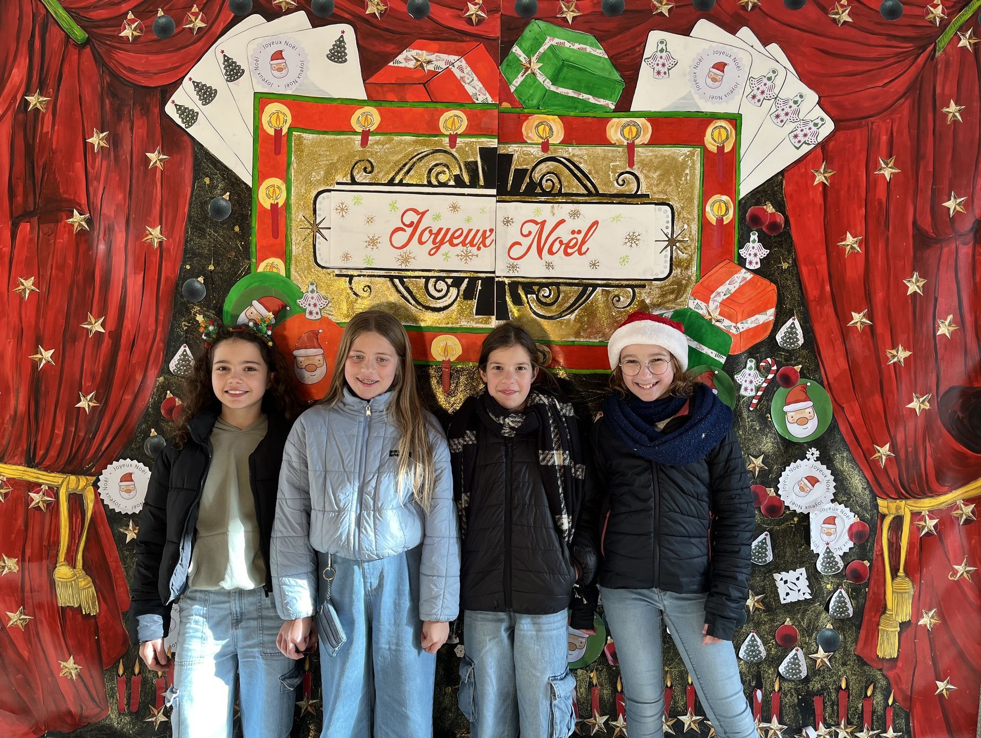 Des élèves devant des décorations de Noël qui sourient pour une photo