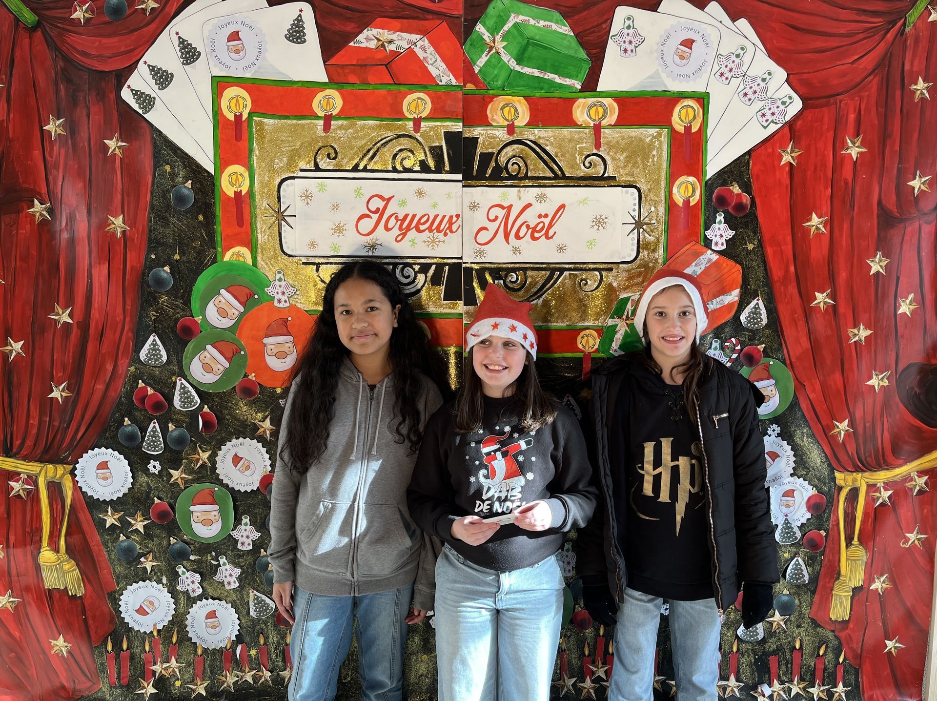 Trois filles qui sourient pour une photo devant des décorations de Noël 