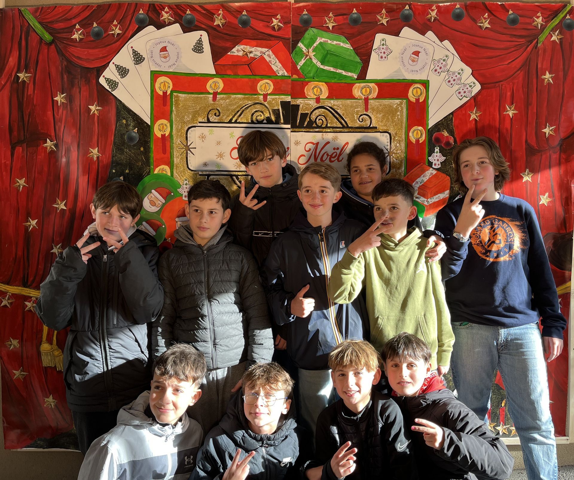 Un groupe de garçons devant un décor de Noël et qui sourient pour une photo