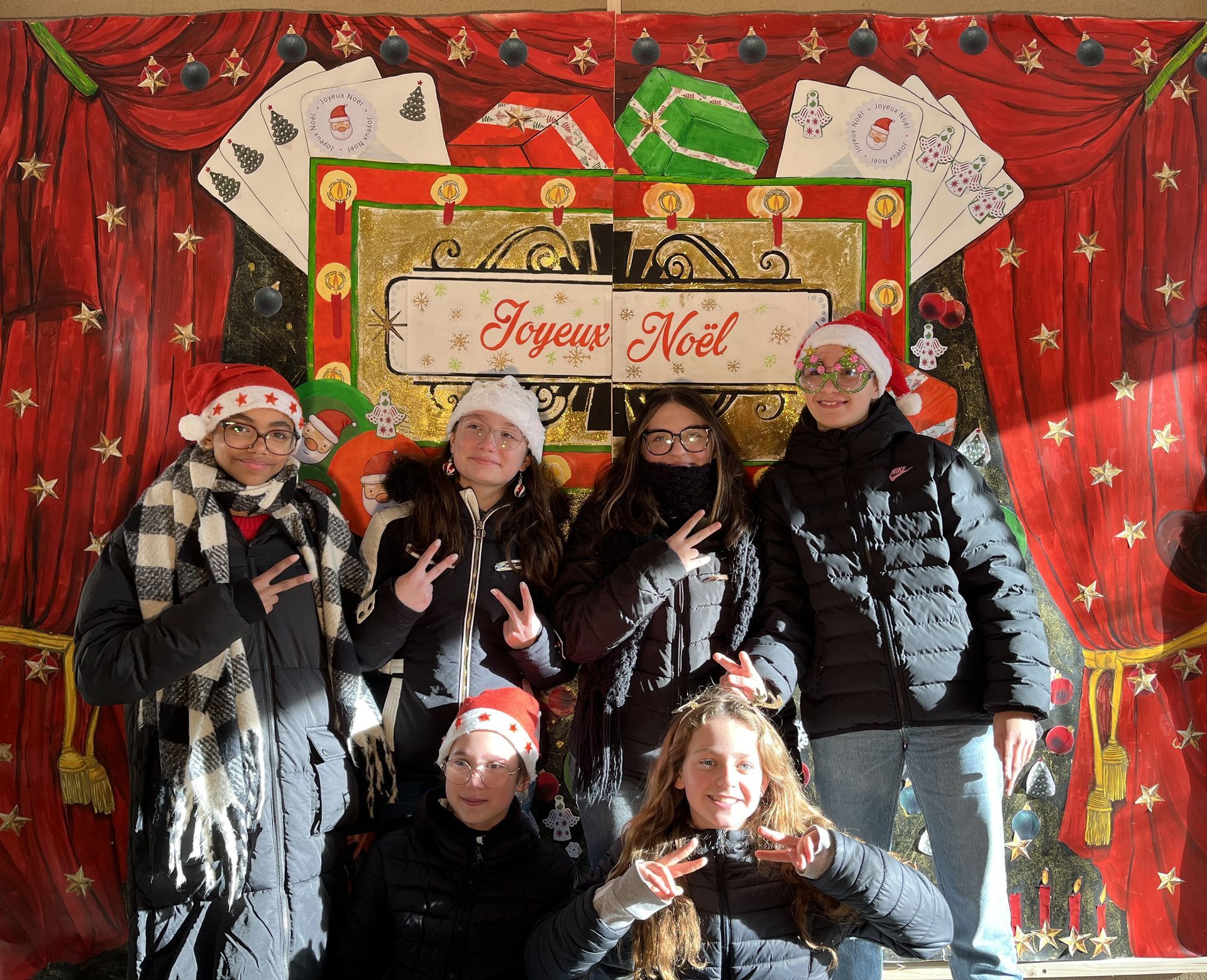 Des élèves devant un décor pour les fêtes qui sourient