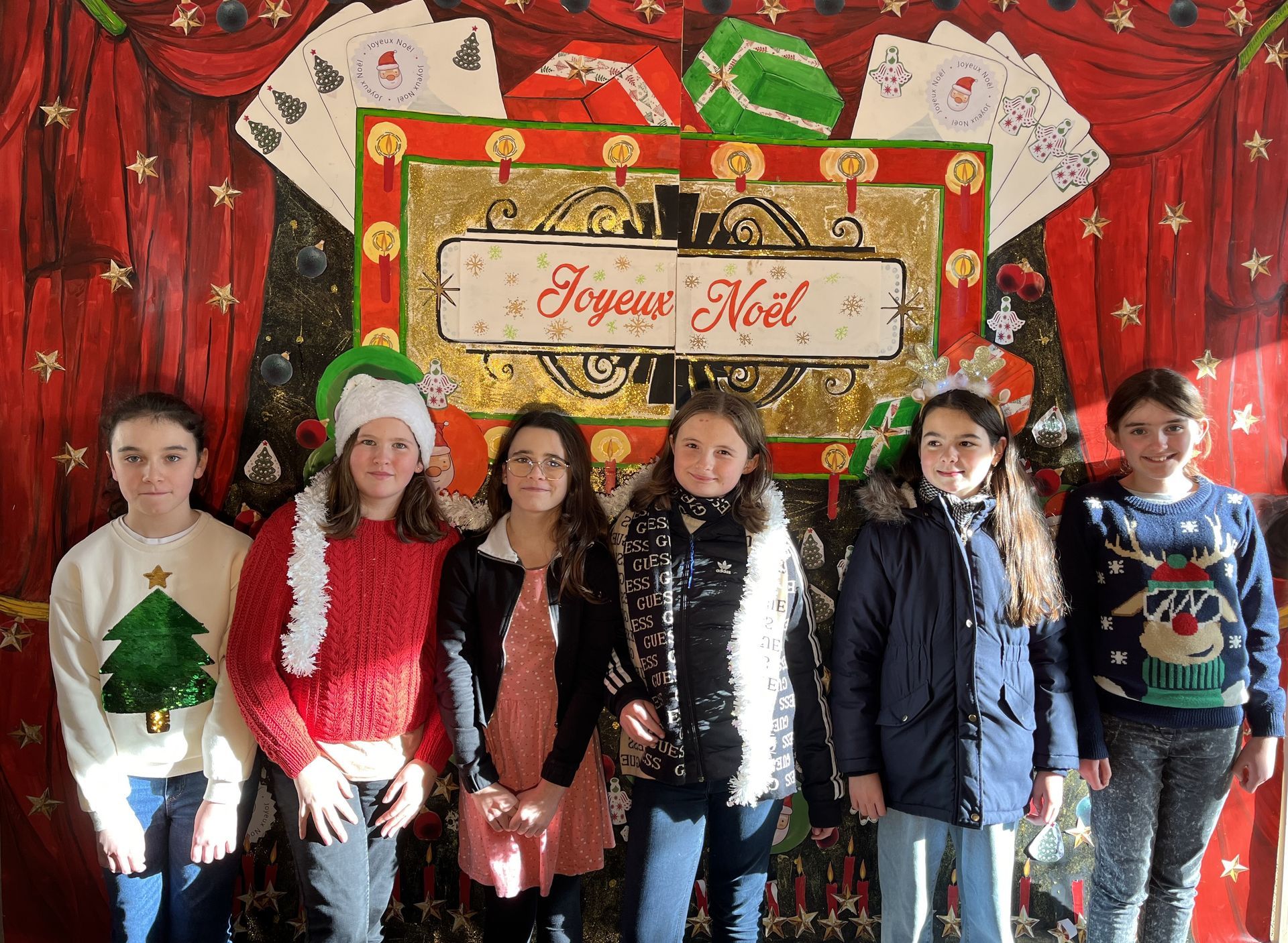 Un décor pour les fêtes et des élèves devant ce décor
