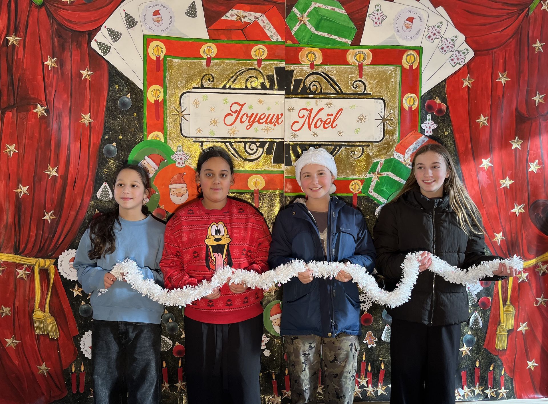Des collégiens devant des décorations pour les fêtes prenant la pose pour une photo