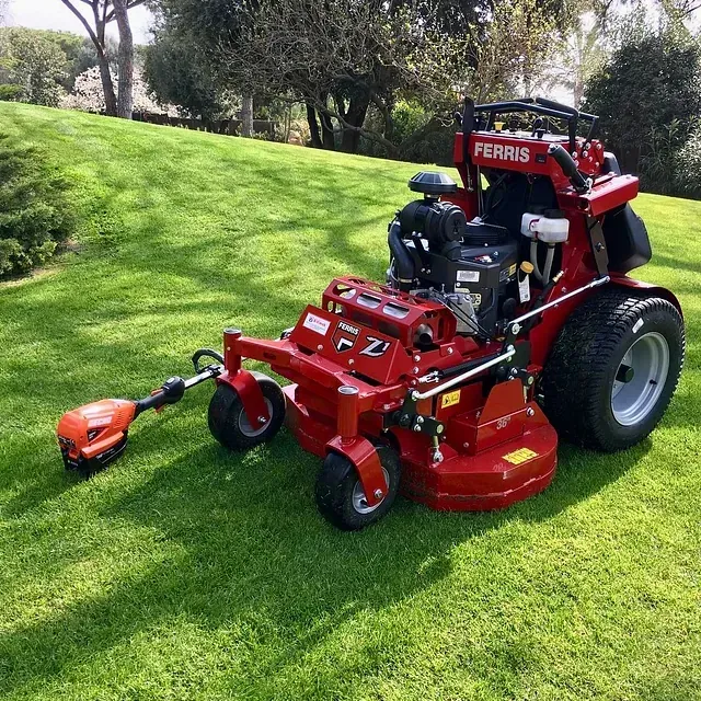 Una cortadora de césped roja con forma de ferris está estacionada en el césped